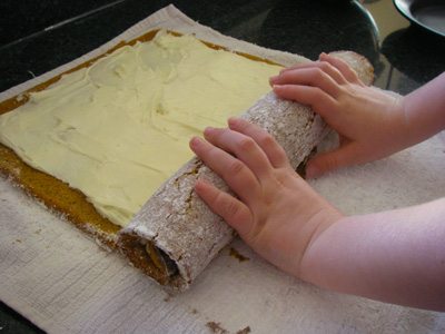 My daughter rolls up the cake roll with filling