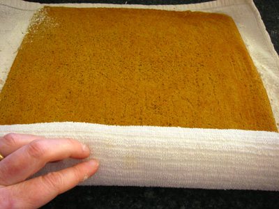 Rolling up the cake in a clean cloth sprinkled with powdered sugar